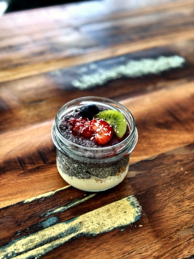 Chia pudding in a jar with berries, kiwi and coconut