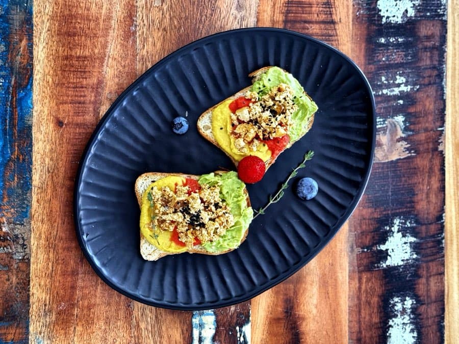Gluten free rainbow bread with avocado cream, turmeric hummus and scrambled tofu